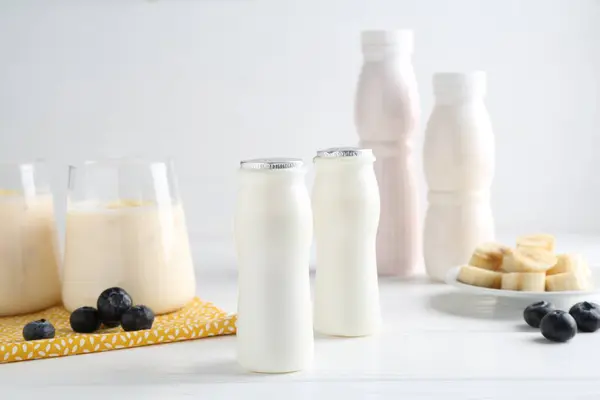 Lezat Yogurt Dalam Botol Pisang Dan Blueberry Atas Meja Kayu — Stok Foto