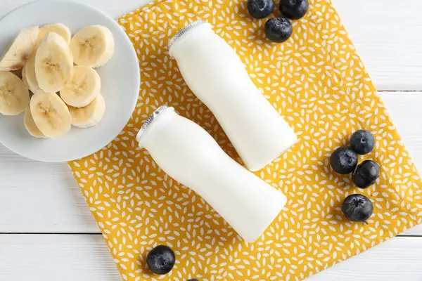 Tasty Yogurt Bottles Banana Blueberries White Wooden Table Top View — Stock Photo, Image