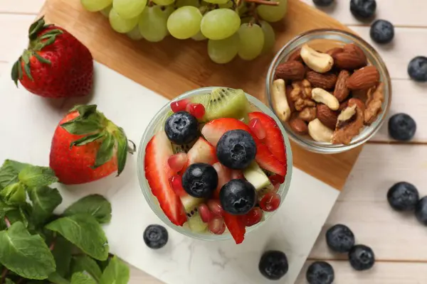 Sunn Frokost Deilig Fruktsalat Glass Nøtter Ingredienser Lyst Trebord Flatlegging – stockfoto