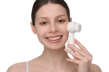 Yüzünü yıka. Beyaz arka planda temizlik fırçası olan genç bir kadın.