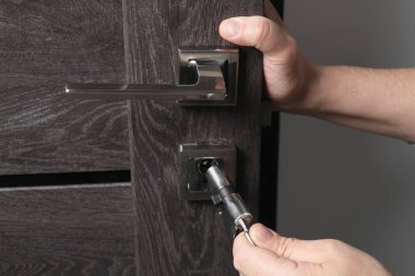 Tamirci kapının çekirdeğini değiştiriyor. Kapıları kilitliyor, kapatıyor.