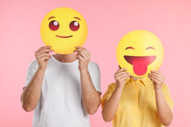 Pembe arka planda yüz ifadelerini gizleyen insanlar