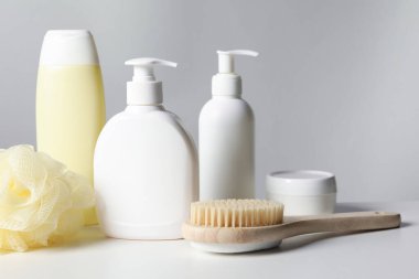 Beyaz masadaki farklı banyo aksesuarları gri arka plan, yakın plan