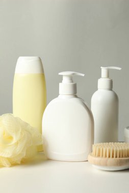Gri arka planda beyaz masadaki farklı banyo aksesuarları