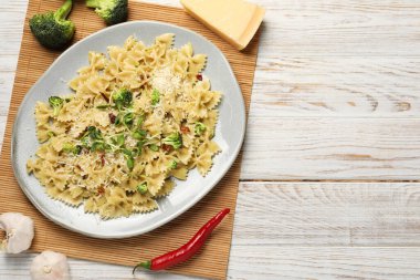 Vejetaryen yemeği. Taze sebzeli lezzetli makarna ve beyaz ahşap masada peynir, üst manzara. Metin için boşluk