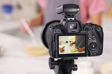Mutfakta video kaydederken yemek blogcusu yemek pişiriyor, kameraya odaklan