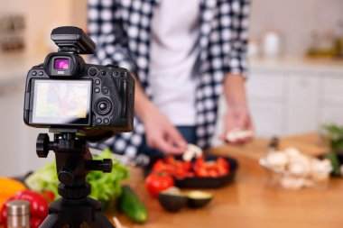 Mutfakta video kaydederken yemek blogcusu yemek pişiriyor, kameraya odaklan