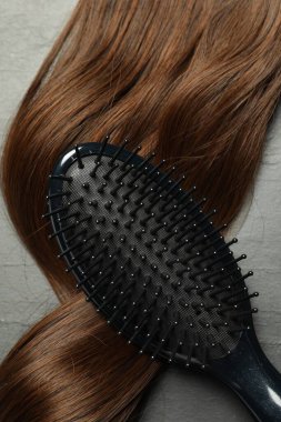 Kahverengi saç telli şık fırça koyu gri masa, üst manzara