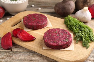 Vejetaryen ürünü. Pişmemiş pancar pirzolası ve ahşap masada malzemeler.