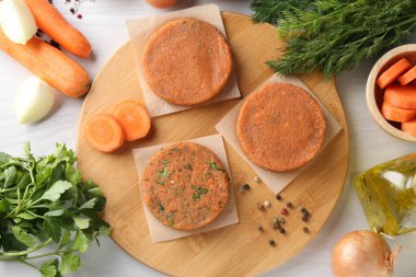 Vejetaryen ürünü. Pişmemiş havuç pirzolası ve malzemeler açık ahşap masada, düz yerde.