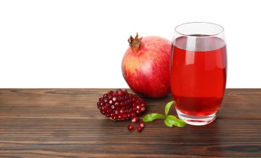 Nar suyunu bardakta, yaprakları ve meyveleri beyaz arka planda serinletiyor. Metin için boşluk