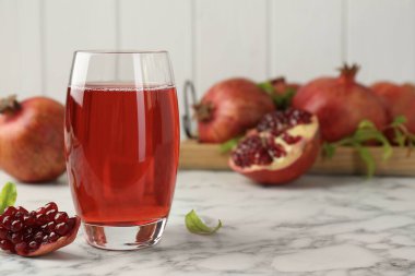 Bardakta lezzetli nar suyu ve beyaz mermer masada taze meyve. Metin için boşluk