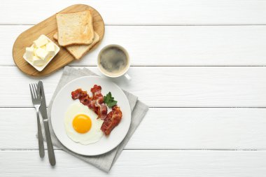 Beyaz ahşap masada servis edilen güneşli kenarlı yumurtalı nefis bir kahvaltı. Metin için boşluk