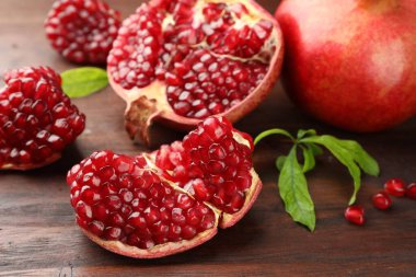 Taze nar ve yeşil yapraklar ahşap masada, yakın plan.