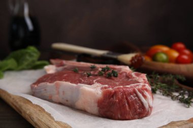 Tahta masada çiğ et ve kekik, yakın plan.