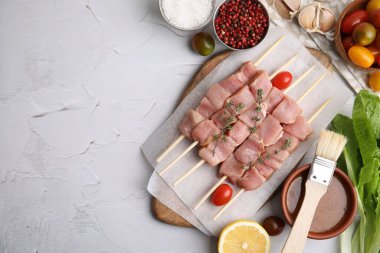 Çiğ et, kekik, domates ve salamura ile açık dokuma masasında şişlerin düz kompozisyonu. Metin için boşluk