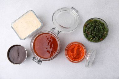 Different marinades on light table, flat lay clipart