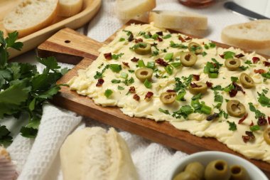 Taze tereyağı, dilimlenmiş zeytin, soğan ve kurutulmuş domates.