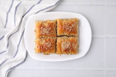 Doğu tatlıları. Lezzetli baklava parçaları beyaz fayanslı masa, üst görünüm