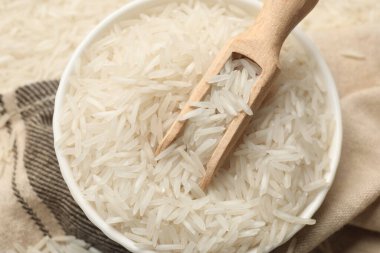 Tabakta çiğ basmati pilavı ve kumaş kepçesi.