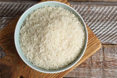 Tabakta çiğ basmati pilavı, ahşap masa, üst manzara.