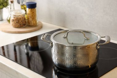 Yemek pişiriyorum. Mutfakta tencerenin üstünde.