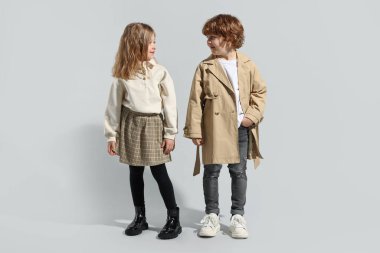 Moda konsepti. Açık gri arka planda poz veren şık çocuklar
