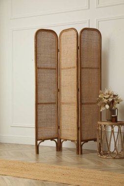 Katlanan ekran ve içinde çiçekler olan küçük bir masa. İç tasarım