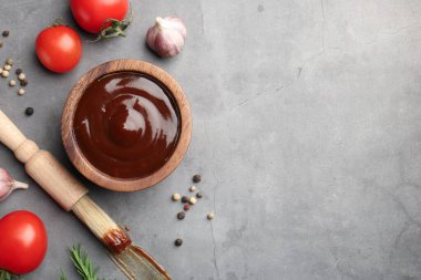 Düz kompozisyon ve lezzetli barbekü sosu gri desenli masada kasede duruyordu. Metin için boşluk