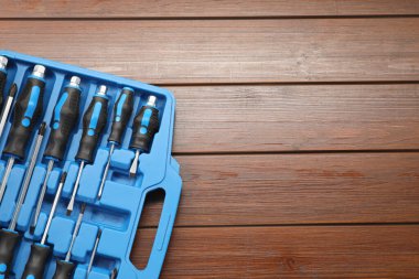 Tahta masadaki açık alet kutusunda tornavida seti, üst manzara. Metin için boşluk