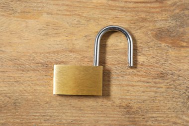 Çelik asma kilit, ahşap masa, üst manzara.