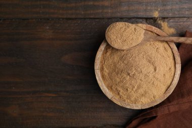 Beslenme lifleri. Kabın içinde psilyum kabuk tozu ve tahta masanın üstünde kaşık, üst manzara. Metin için boşluk