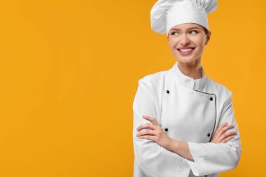 Turuncu arka planda üniformalı mutlu şef, mesaj için yer var.