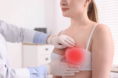 Mamolog hastanede genç bir kadının göğüslerini kontrol ediyor.