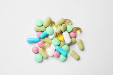 Beyaz arka planda farklı vitamin hapları, üst görünüm