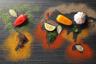 Dünya haritası siyah ahşap masa üzerinde farklı baharat ve ürünler, düz yatıyordu