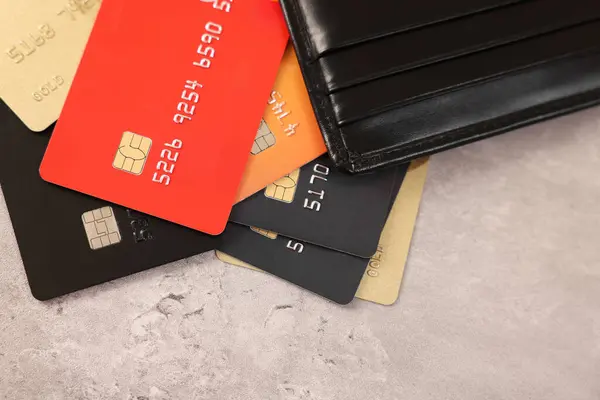 Muitos Cartões Crédito Diferentes Carteira Couro Mesa Cinza Vista Superior — Fotografia de Stock