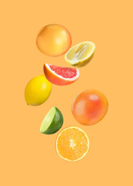 Wiele Różnych Owoców Cytrusowych Spadających Pomarańczowe Tło — Zdjęcie stockowe