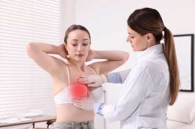 Mamolog hastanede genç bir kadının göğüslerini kontrol ediyor.