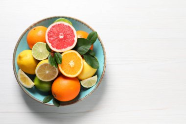 Farklı kesim ve bütün turunçgiller beyaz ahşap masa üzerinde, üst manzara. Metin için boşluk