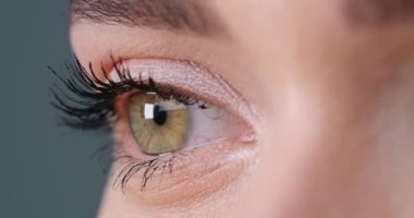 Gri arka planda güzel gözleri olan mutlu kadın, yakın plan. Sağ göze odaklan.