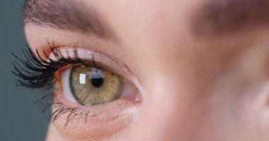 Gri arka planda güzel gözleri olan duygusal bir kadın, yakın plan. Sağ göze odaklan.