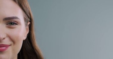  Açık gri arka planda gülümseyen güzel kadın, yakın plan.