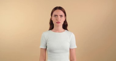  Bej arka planda kızgın genç bir kadın var.