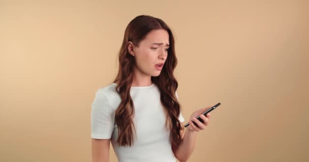 Нещасна Молода Жінка Мобільним Телефоном Отримала Погані Новини Бежевий Фон Відеокліп