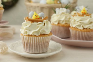 Hafif ahşap masada vanilya kremalı Paskalya kekleri.