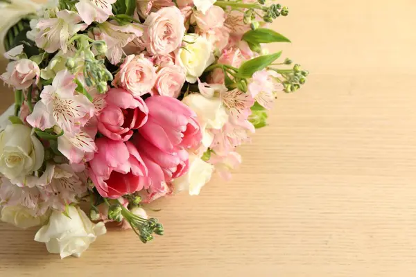 Beautiful bouquet of fresh flowers on wooden table, closeup. Space for text