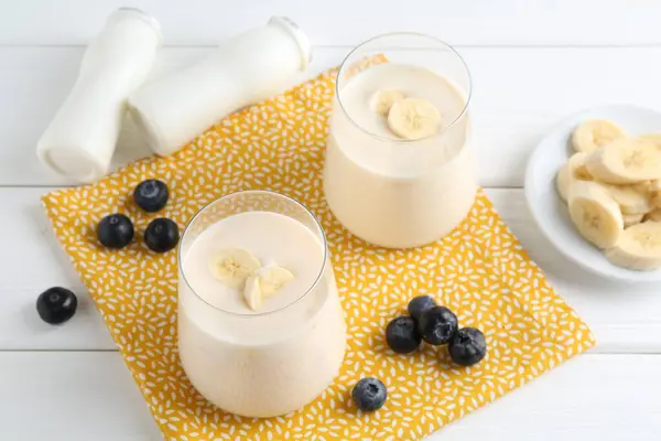 Smaczny Jogurt Banan Jagody Białym Drewnianym Stole — Zdjęcie stockowe