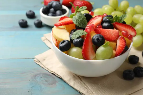 Salată Fructe Gustoasă Bol Ingrediente Masa Lemn Albastru Deschis Closeup — Fotografie, imagine de stoc