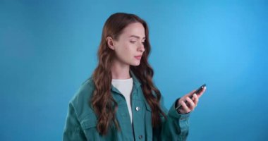  Cep telefonlu hayal kırıklığına uğramış genç bir kadın kötü haberler aldı. Açık mavi arkaplan